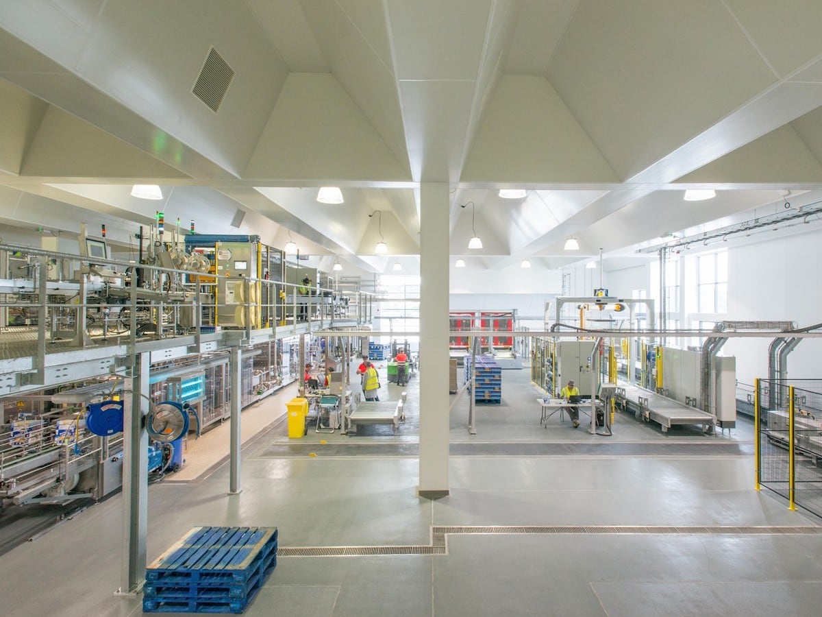 Food and beverage processing facility with hygienic wall cladding, white PVC hygienic wall panels, and stainless steel production equipment